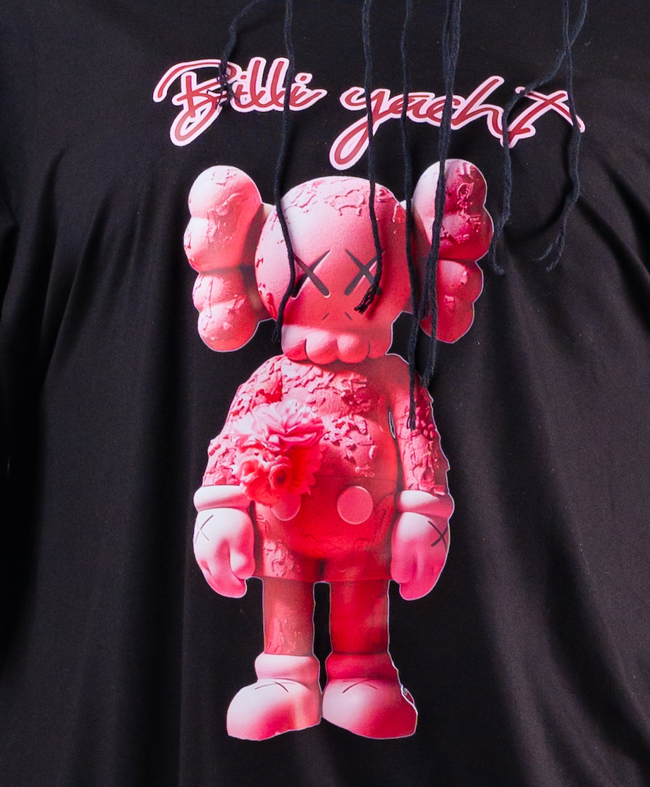 Pink cartoon character held by a person wearing a black hoodie with 'Billi Yacht' text.