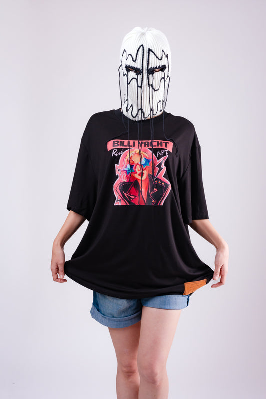 Person wearing a black oversized t-shirt with graphic design and denim shorts on a plain background