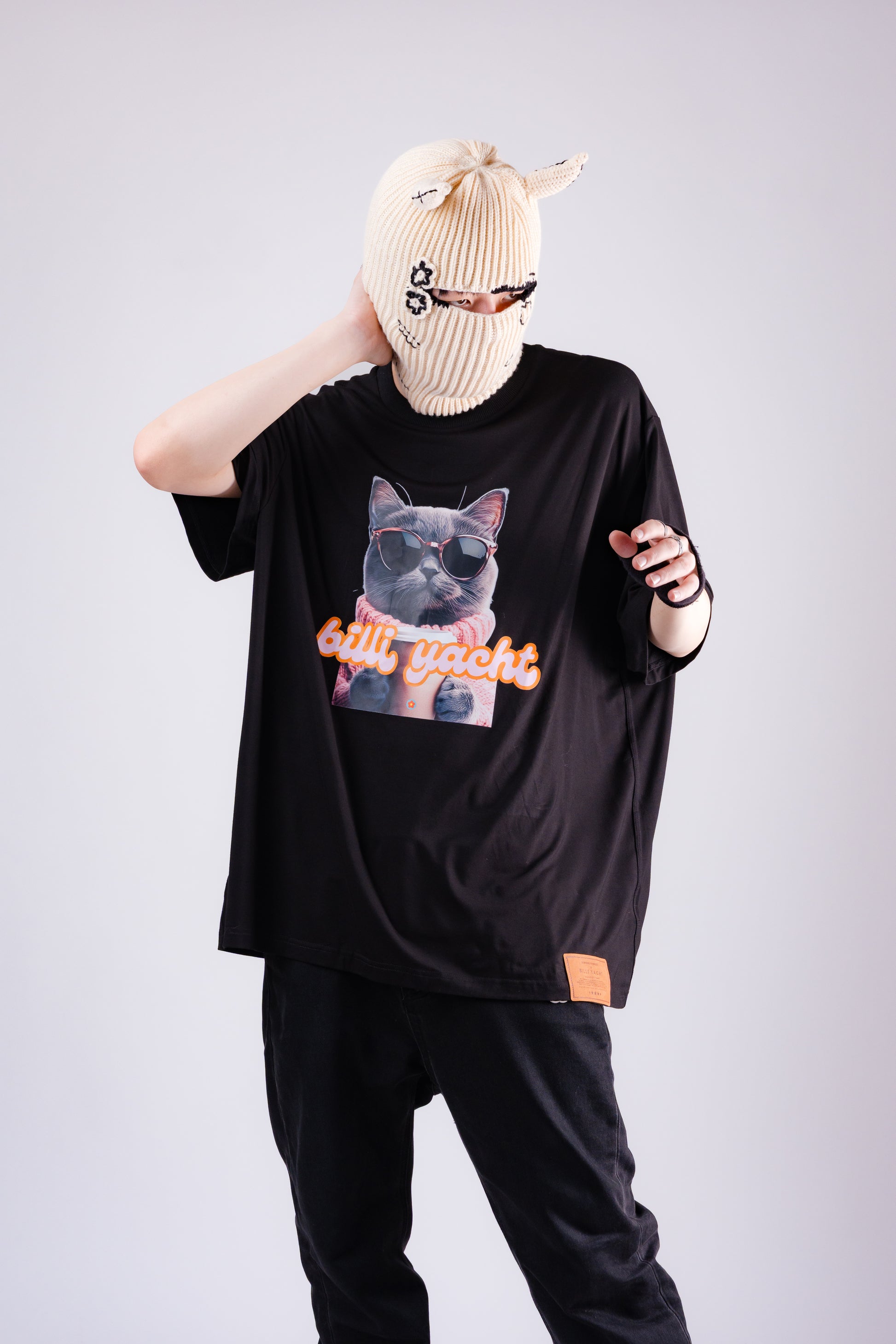 Person wearing a black t-shirt with a graphic design and text, standing against a plain background.